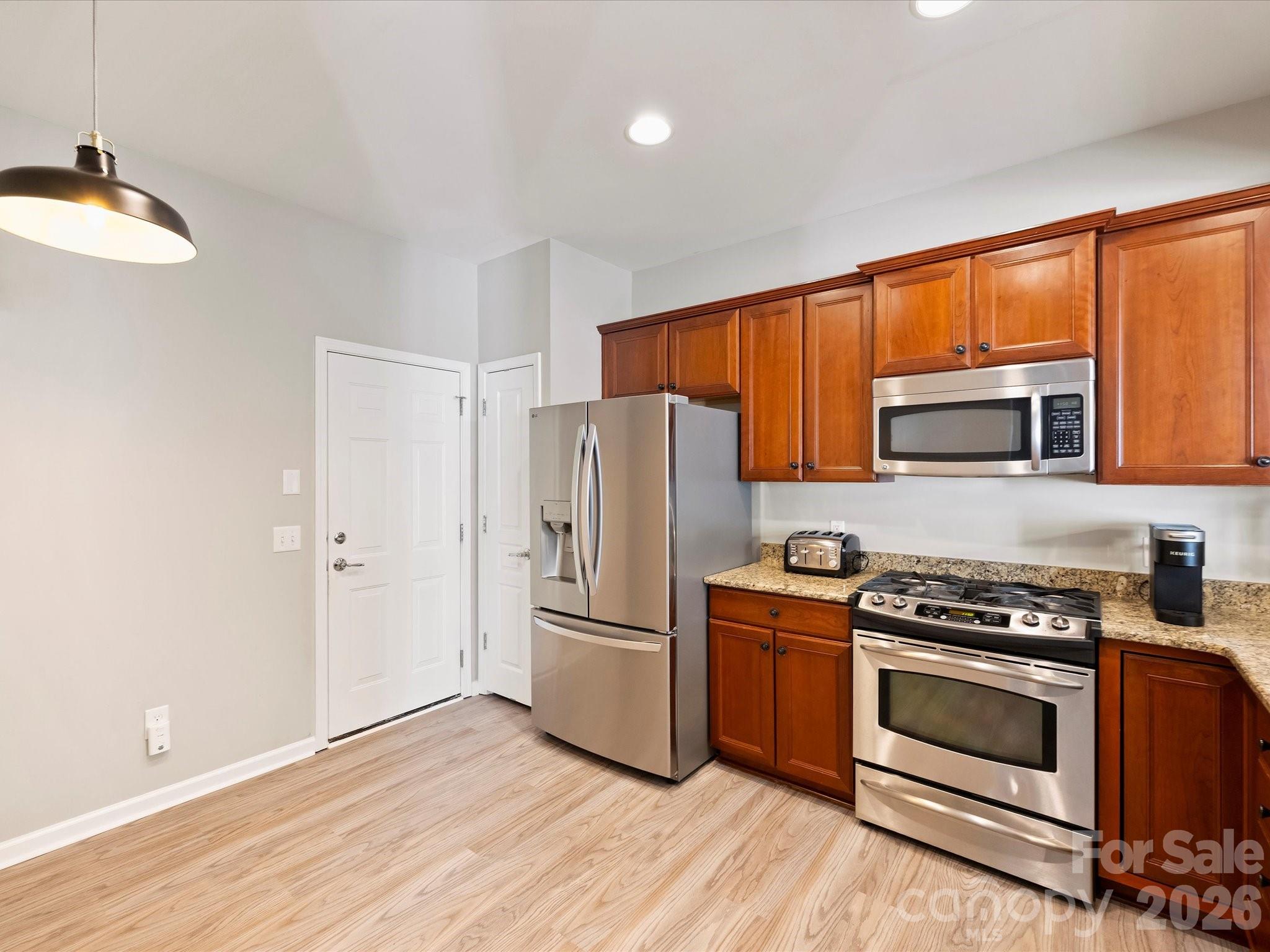 15544 Canmore Street Charlotte, NC 28277 - Photo 14 of 36 a kitchen with granite countertop wooden floors and stainless steel appliances