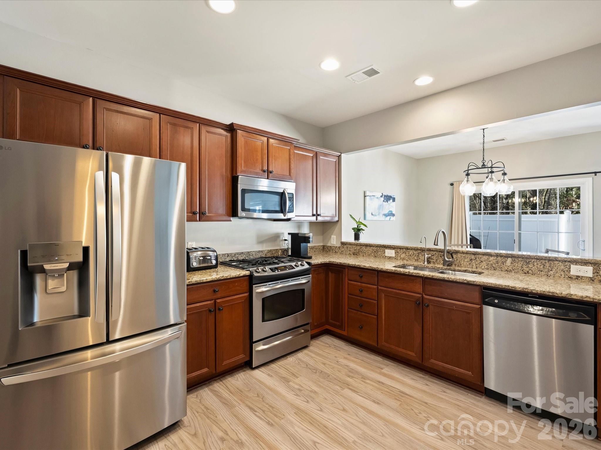 15544 Canmore Street Charlotte, NC 28277 - Photo 15 of 36 a kitchen with granite countertop stainless steel appliances and wooden cabinets