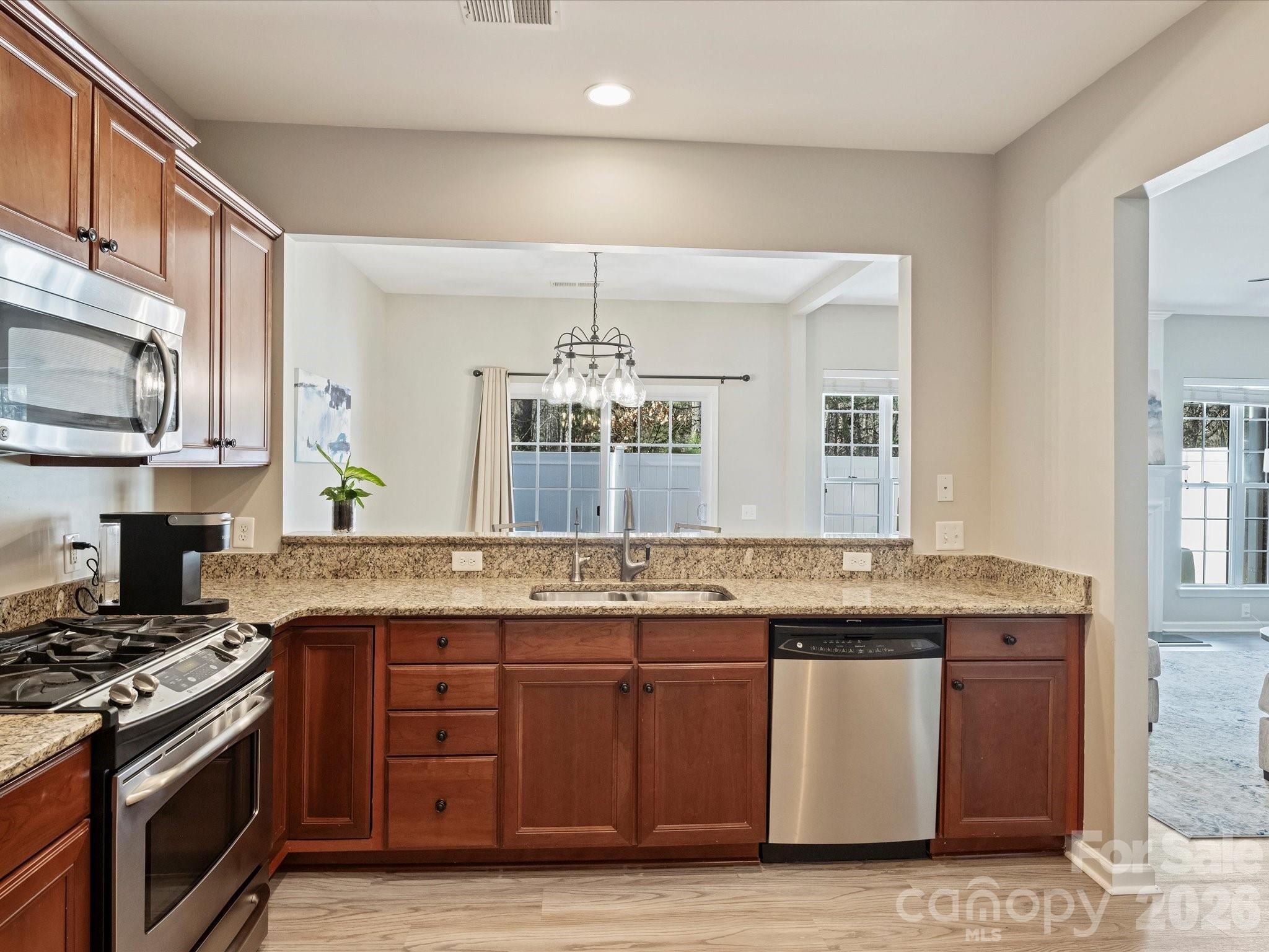 15544 Canmore Street Charlotte, NC 28277 - Photo 17 of 36 a kitchen with stainless steel appliances granite countertop a stove a sink and a microwave