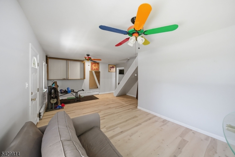 251 Russia Road Oak Ridge, NJ 07438 - Photo 14 of 34 a view of a livingroom with wooden floor and a ceiling fan