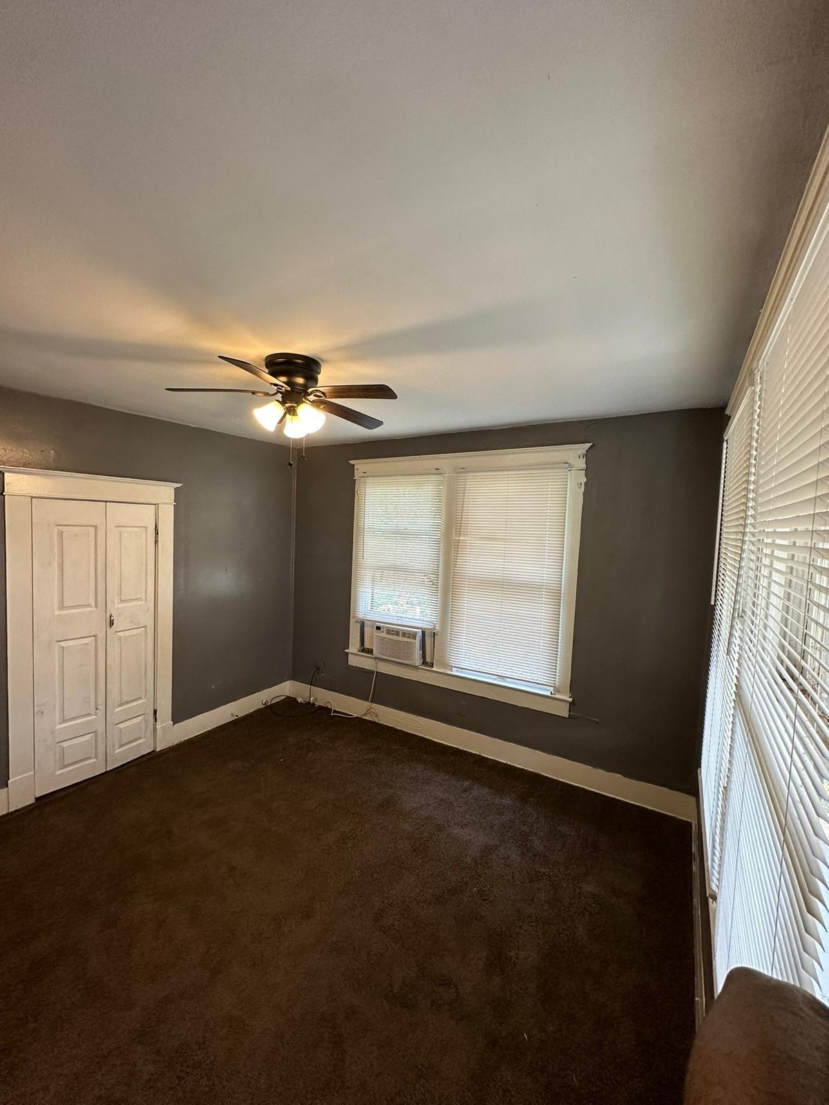 6818 Stearns Street Houston, TX 77021 - Photo 14 of 18 an empty room with windows and chandelier fan