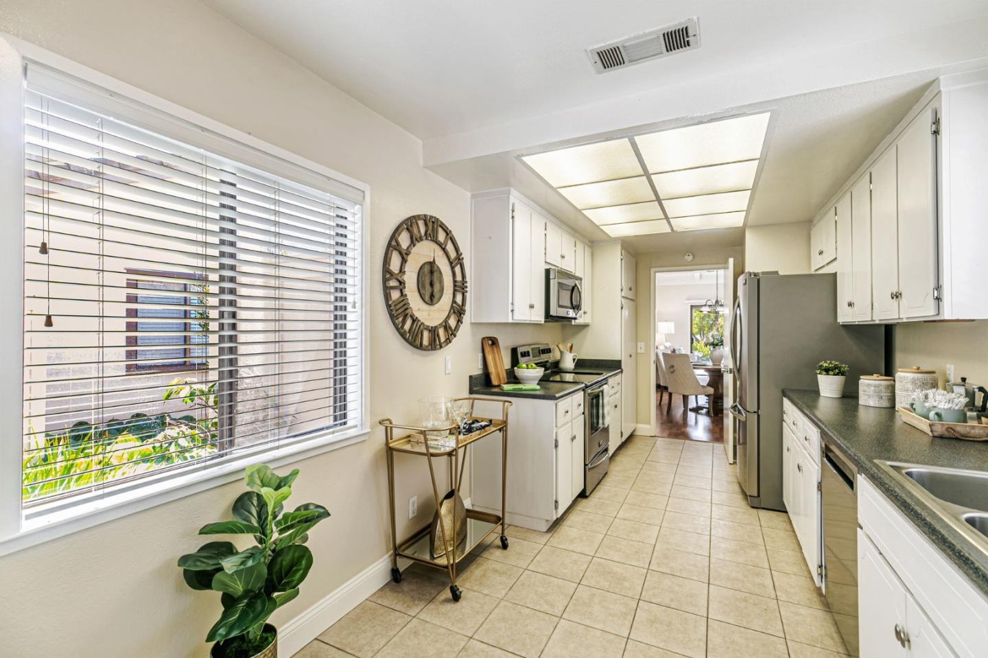 6200 Gerdts Drive San Jose, CA 95135 - Photo 18 of 39 a kitchen with stainless steel appliances a white table a stove a microwave and cabinets