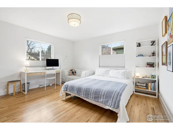 a bedroom with a bed and a painting on the wall