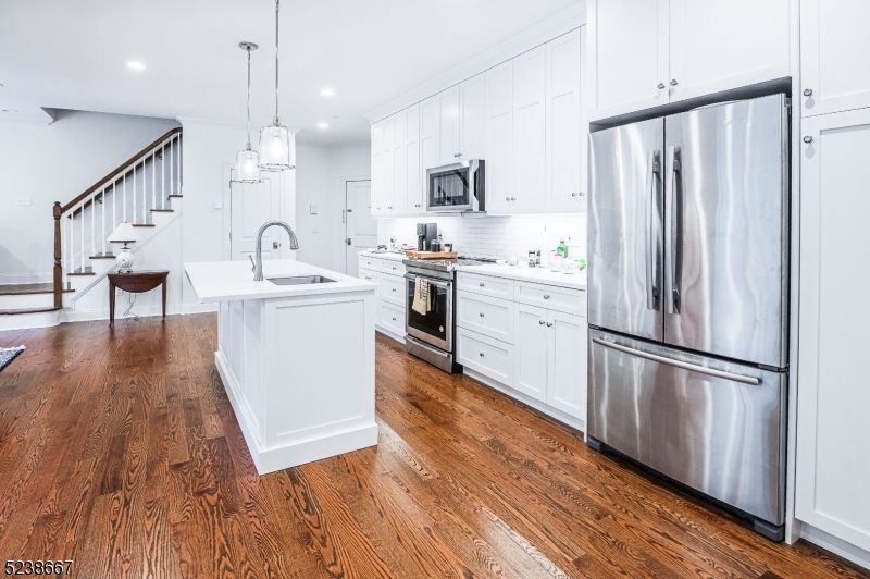 29 Euclid Avenue, Unit 203 Summit, NJ 07901 - Photo 7 of 25 a kitchen with stainless steel appliances a refrigerator a sink cabinets and wooden floor