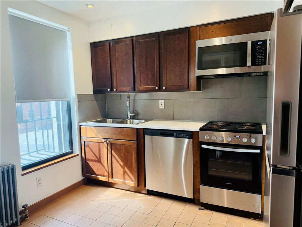 196 23rd Street Brooklyn, NY 11232 - Photo 2 of 11 a kitchen with granite countertop wooden cabinets and stainless steel appliances