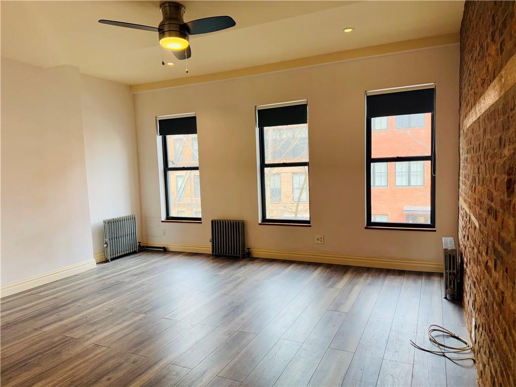 196 23rd Street Brooklyn, NY 11232 - Photo 3 of 11 a view of an empty room with wooden floor and a window