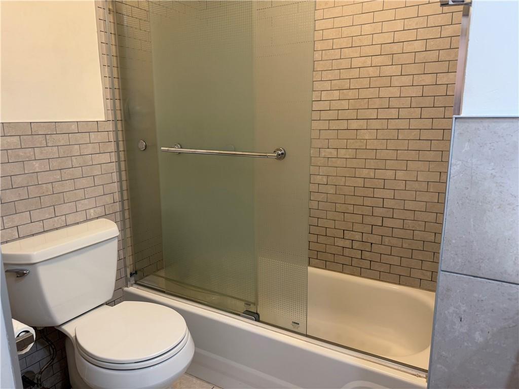 196 23rd Street Brooklyn, NY 11232 - Photo 10 of 11 a white toilet sitting next to a bath tub
