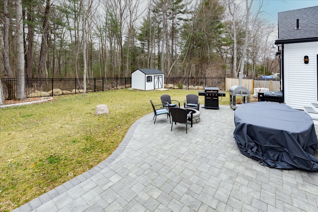 5 Brookside Lane Burlington, MA 01803 - Photo 34 of 42 a view of a backyard with table and chairs couches with wooden fence