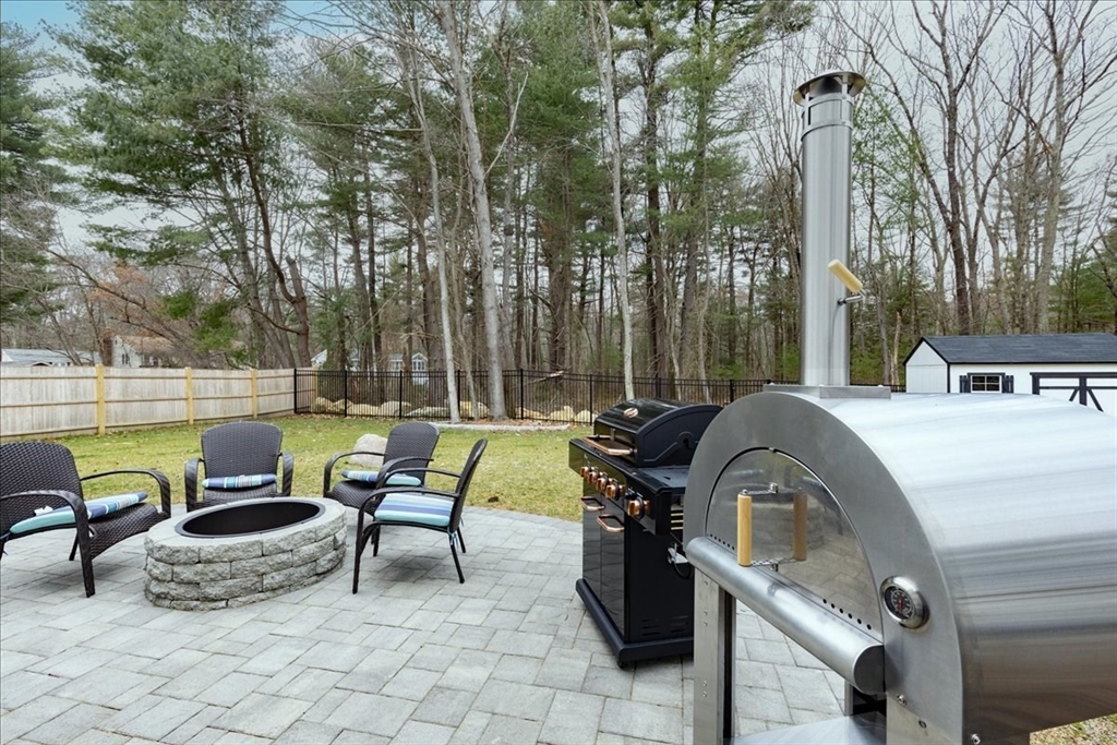 5 Brookside Lane Burlington, MA 01803 - Photo 35 of 42 a view of a patio with table and chairs potted plants and a large tree