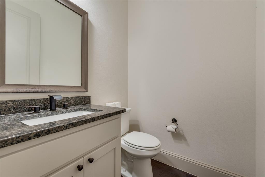 2021 Calisto Way Allen, TX 75013 - Photo 18 of 34 Bathroom vanity with a dark speckled countertop, integrated white sink, and dark bronze faucet