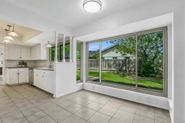 a kitchen with a large window and white cabinets