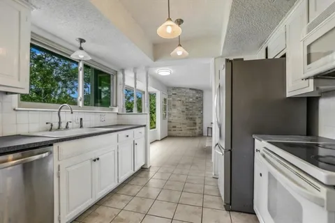 a kitchen with sink cabinets and window