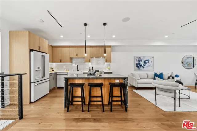 a living room with kitchen island a table and chairs in it