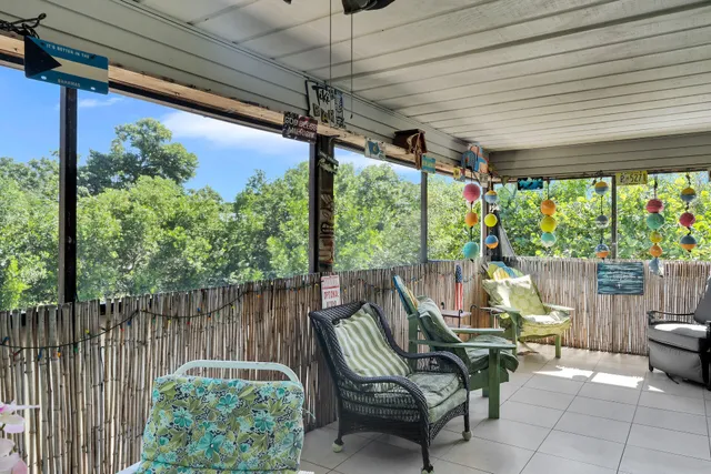 a view of a porch with furniture and a backyard