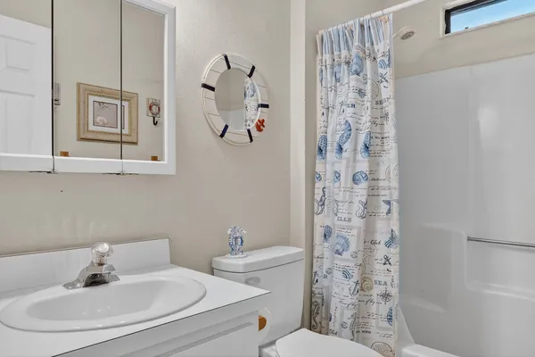 a bathroom with a sink a toilet and shower curtain
