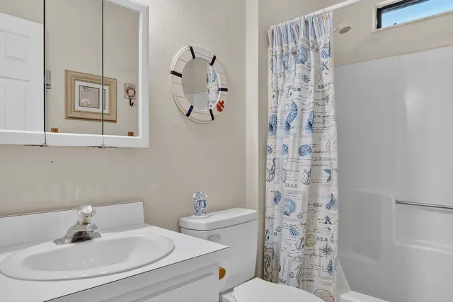 a bathroom with a sink a toilet and shower curtain