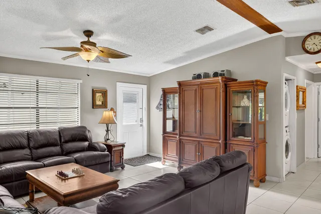 a living room with furniture a refrigerator and a window