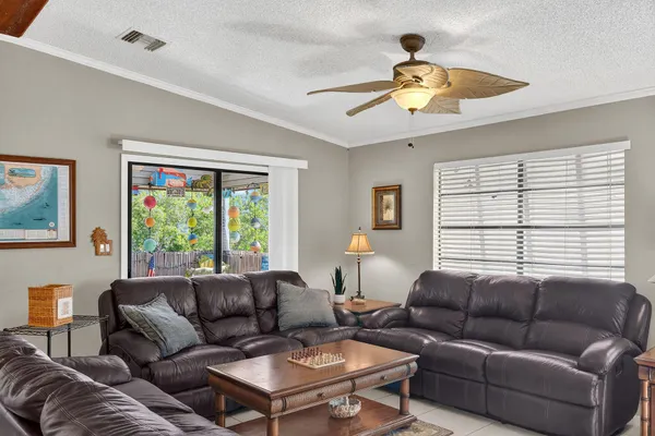 a living room with furniture a ceiling fan and a window