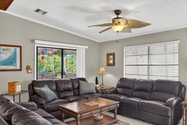 a living room with furniture a ceiling fan and a window