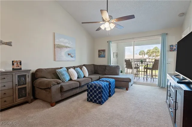 a living room with furniture a flat screen tv and a window