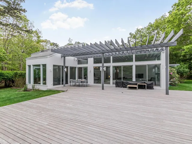 a bathroom with a toilet a sink a mirror and a window