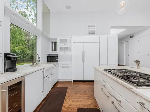 a kitchen with stainless steel appliances a table and chairs in it