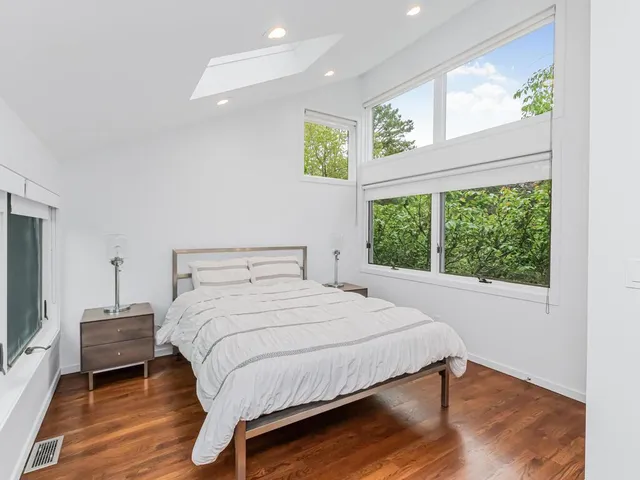 a view of a bedroom with wooden floor and windows