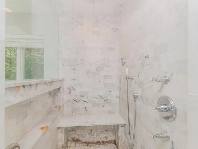 a bedroom with a bed and a large window