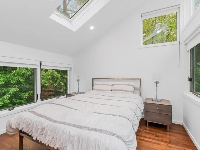 a large bed sitting in a bedroom next to a window