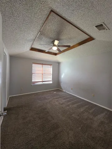 en empty room with windows and ceiling fan