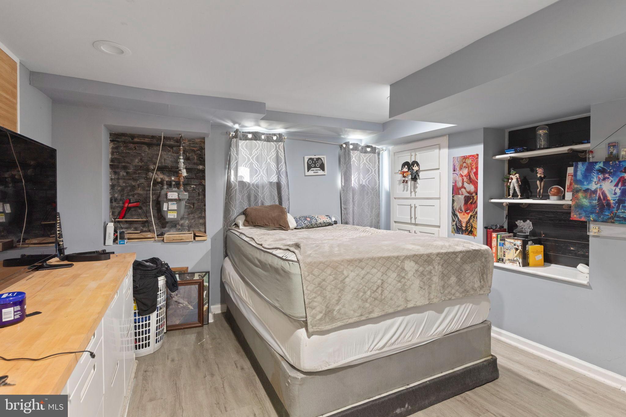 406 South Smallwood Street Baltimore, MD 21223 - Photo 14 of 18 a bedroom with a bed and dresser with wooden floor