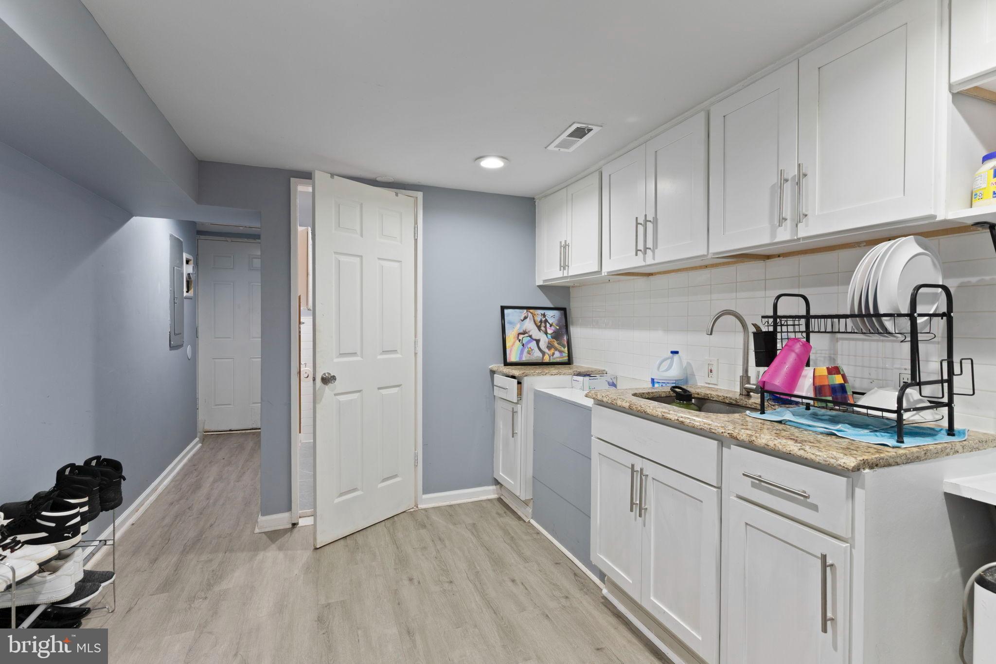 406 South Smallwood Street Baltimore, MD 21223 - Photo 15 of 18 a kitchen with a sink stove and cabinets