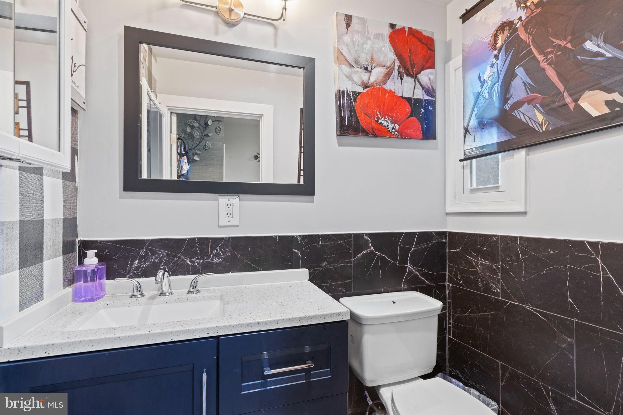 406 South Smallwood Street Baltimore, MD 21223 - Photo 7 of 18 a bathroom with a toilet a sink and mirror
