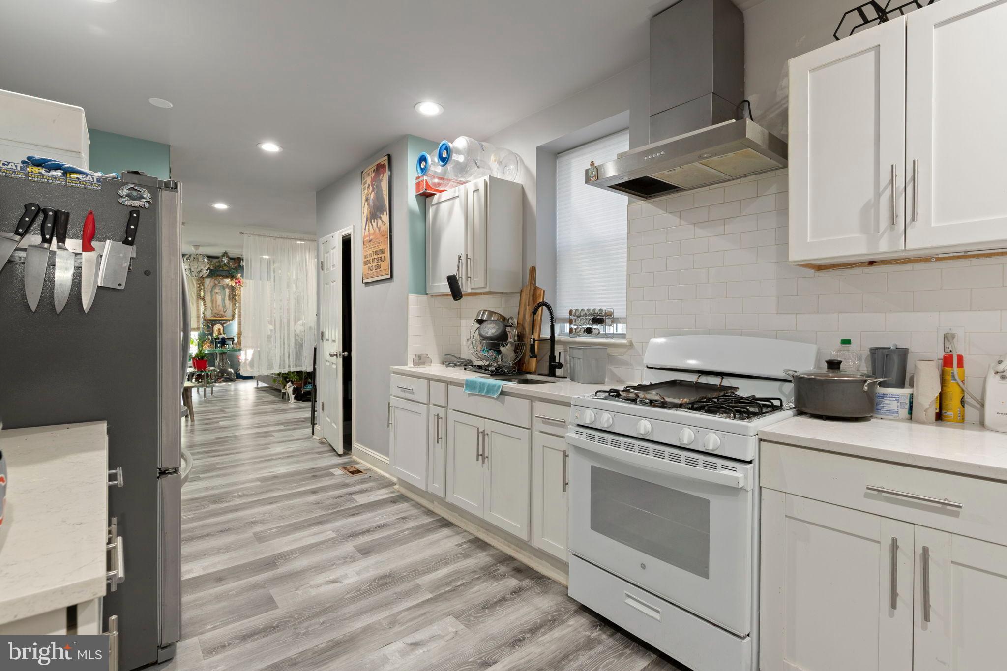 406 South Smallwood Street Baltimore, MD 21223 - Photo 10 of 18 a kitchen with stainless steel appliances granite countertop a stove a sink dishwasher and a refrigerator with wooden floor