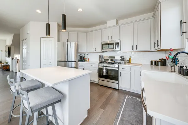 a kitchen with white cabinets stainless steel appliances and sink