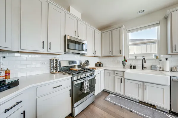 a kitchen with refrigerator a dining table and chairs