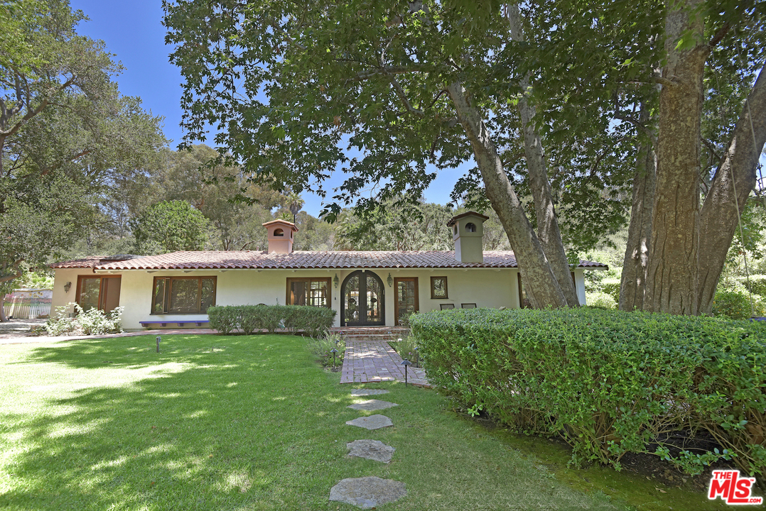 6138 Ramirez Canyon Road Malibu, CA 90265 - Photo 1 of 42 a front view of a house with a garden and trees