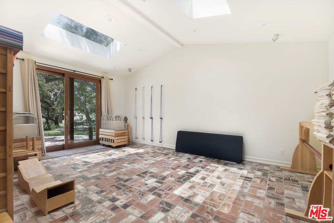 6138 Ramirez Canyon Road Malibu, CA 90265 - Photo 19 of 42 a living room with a bed furniture and a large window
