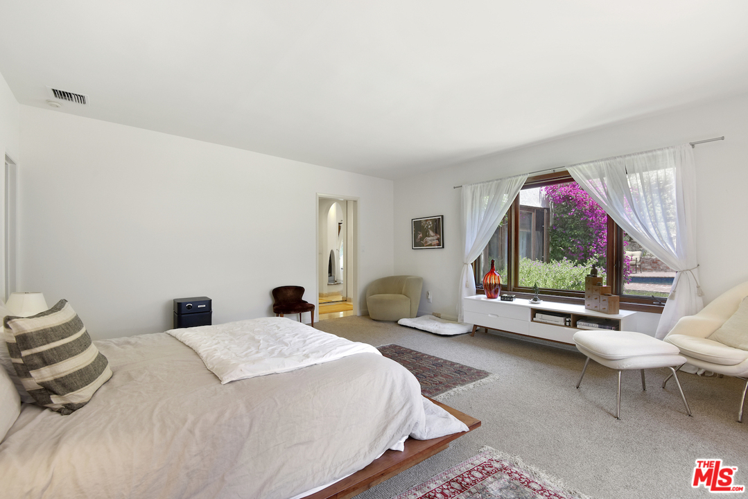 6138 Ramirez Canyon Road Malibu, CA 90265 - Photo 23 of 42 a bedroom with a bed and a large window