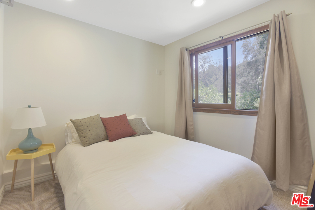 6138 Ramirez Canyon Road Malibu, CA 90265 - Photo 35 of 42 a bedroom with a bed and a window