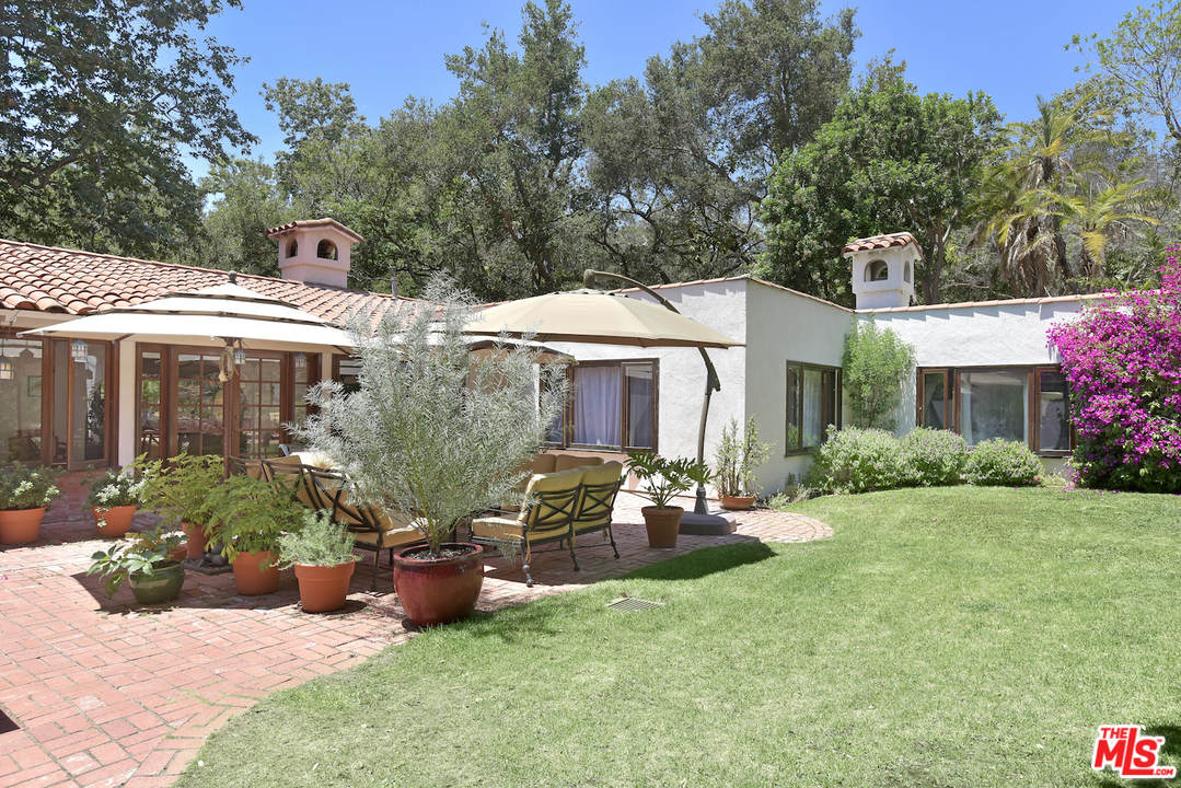 6138 Ramirez Canyon Road Malibu, CA 90265 - Photo 39 of 42 a view of a patio with table and chairs under an umbrella