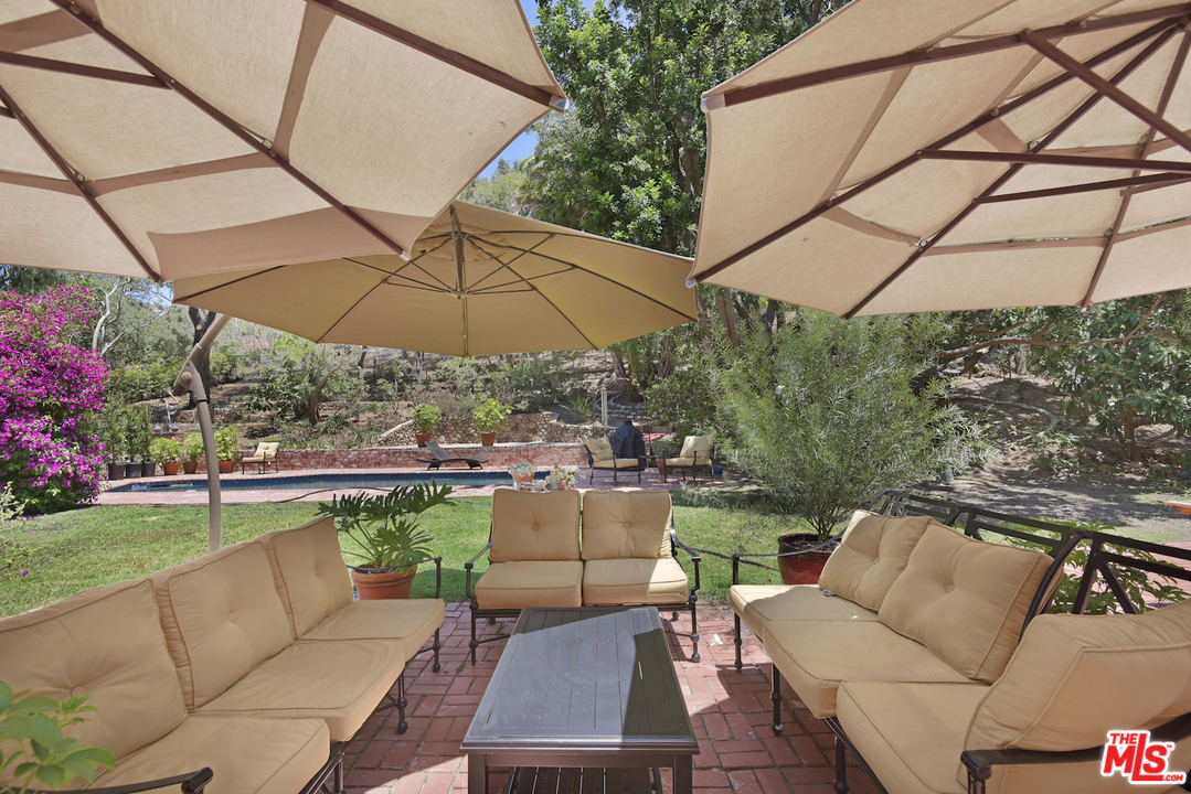6138 Ramirez Canyon Road Malibu, CA 90265 - Photo 40 of 42 a view of a patio with couches under an umbrella