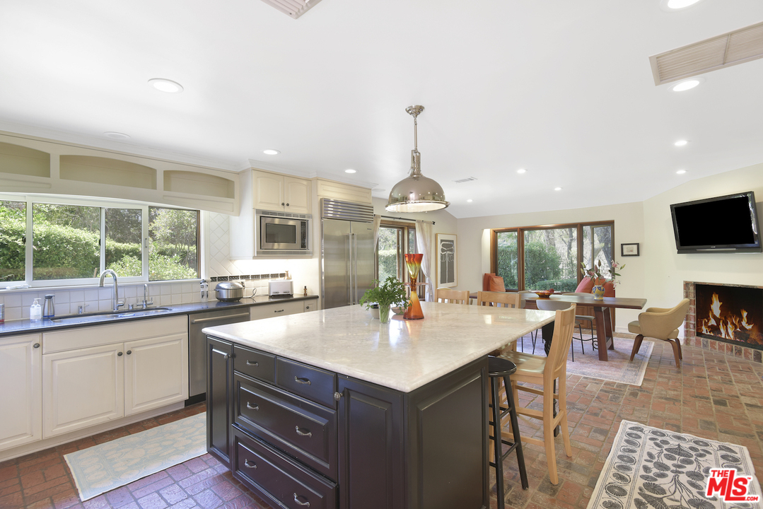 6138 Ramirez Canyon Road Malibu, CA 90265 - Photo 10 of 42 a kitchen with stainless steel appliances granite countertop a sink and a wooden floors
