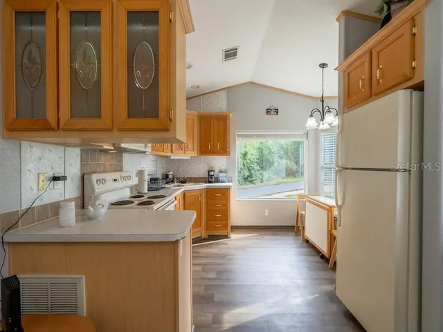 a kitchen with refrigerator a sink and white cabinets