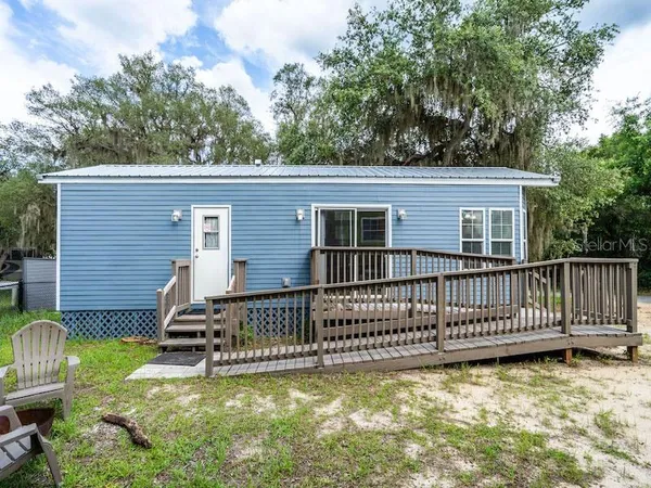 a view of a house with a wooden deck and a yard