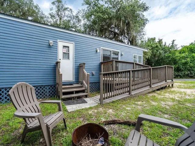 a view of a chair and table in backyard of the house