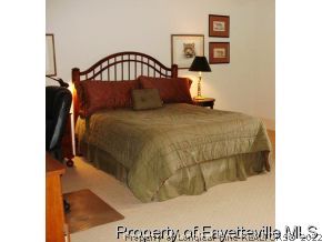 301 Summertime Road Fayetteville, NC 28303 - Photo 16 of 25 a bedroom with a bed and a painting on the wall