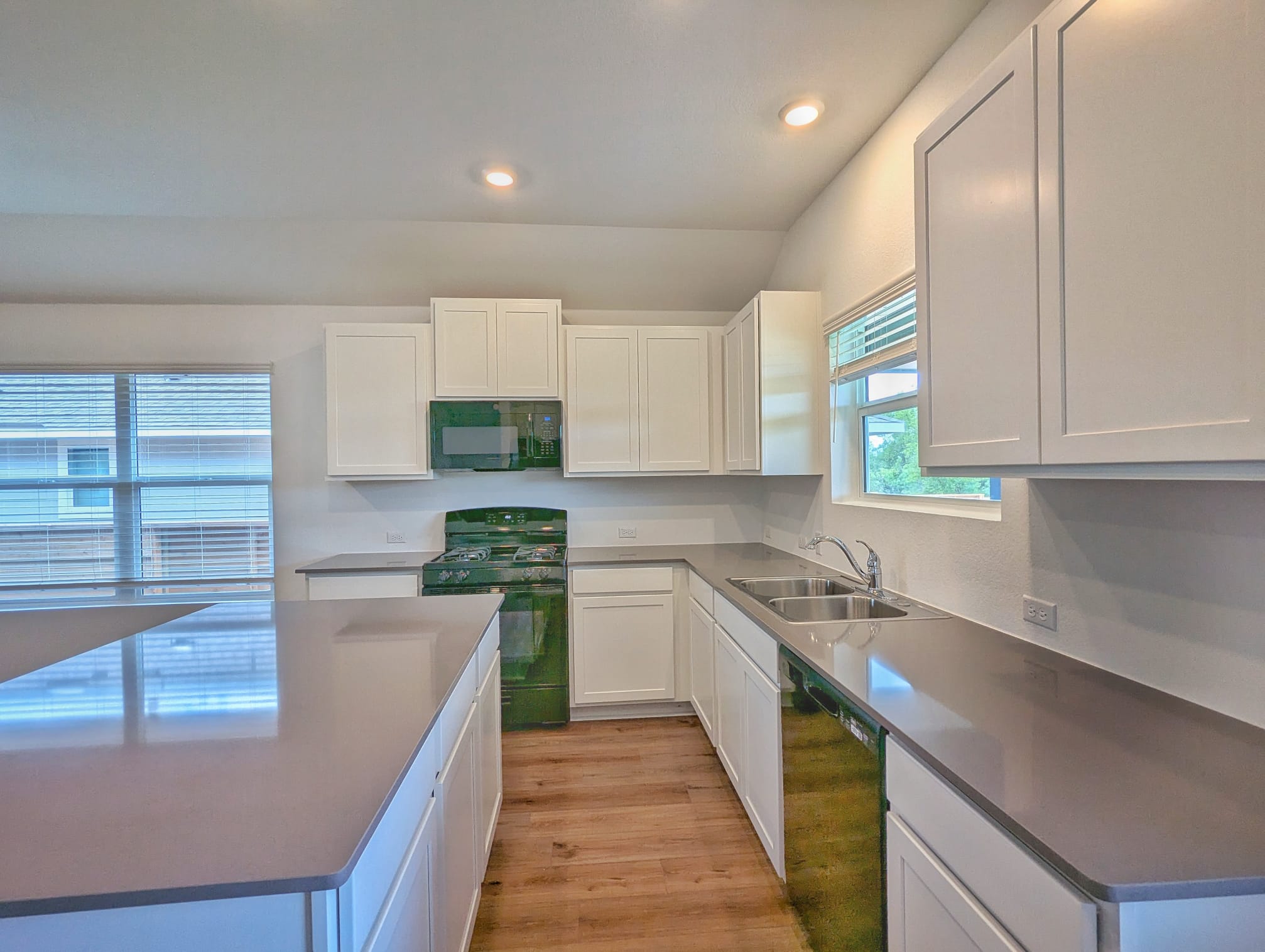 1504 Marley Kyle, TX 78640 - Photo 10 of 28 Kitchen featuring black appliances, white cabinets, recessed lighting, light wood-type flooring, and a kitchen island