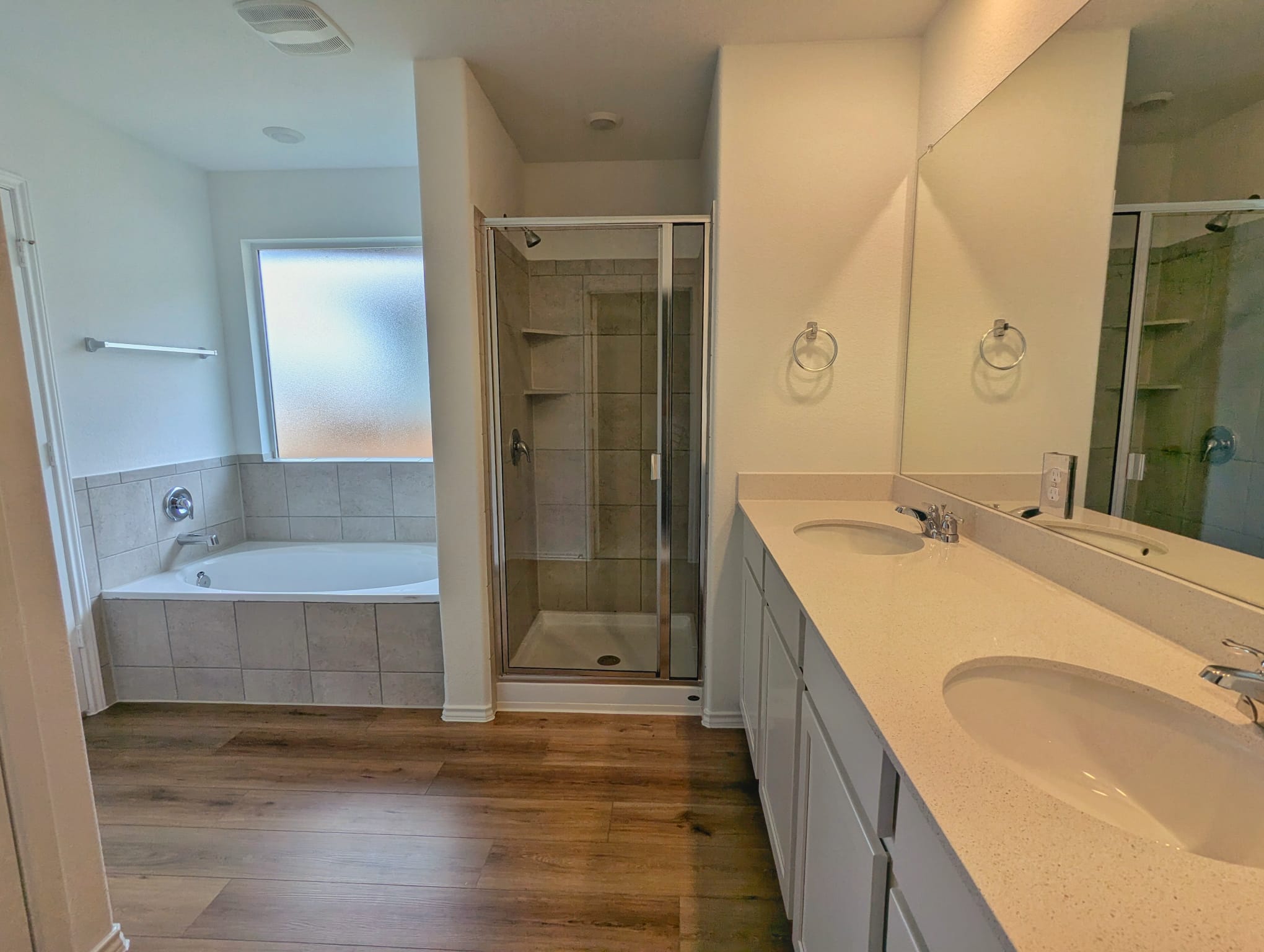 1504 Marley Kyle, TX 78640 - Photo 12 of 28 Full bath with dark wood finished floors, double vanity, a stall shower, and a garden tub