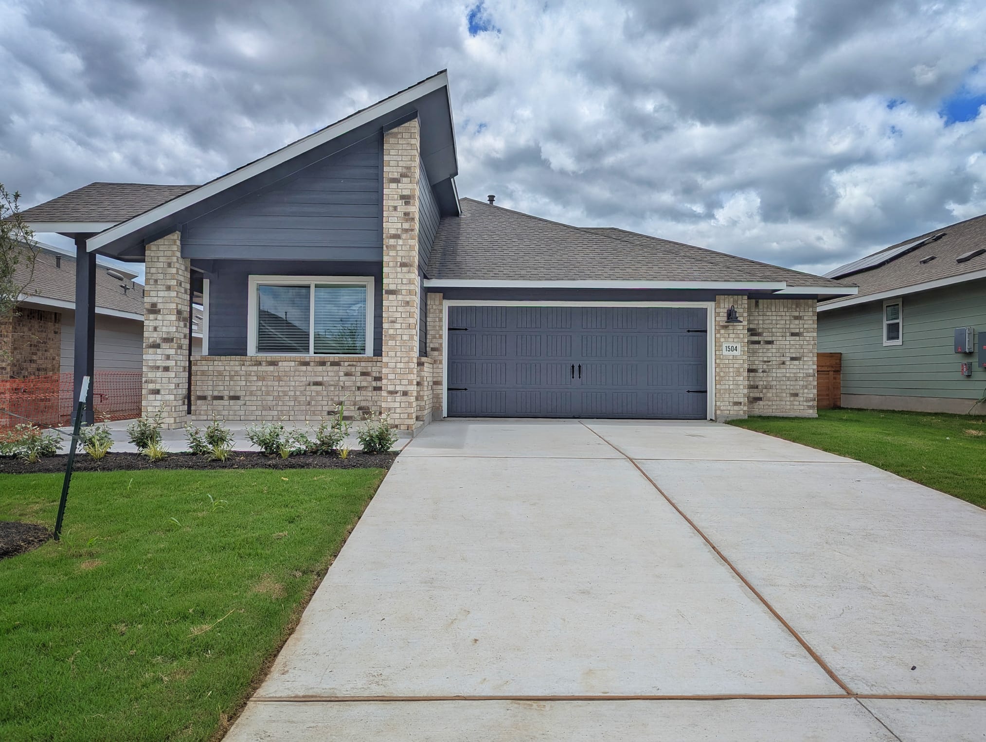 1504 Marley Kyle, TX 78640 - Photo 2 of 28 View of front of house featuring brick siding, a front yard, an attached garage, and concrete driveway